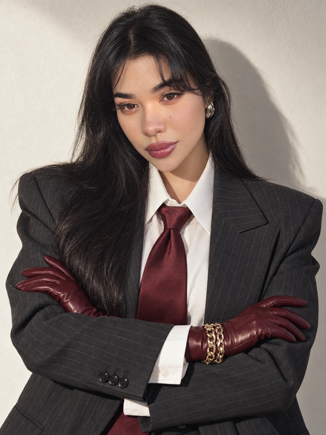 Retrato de Scarlet con traje gris oscuro, corbata y guantes color burdeos, con los brazos cruzados
